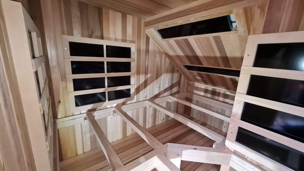 Unfinished wood bench and heater framing in a custom sauna