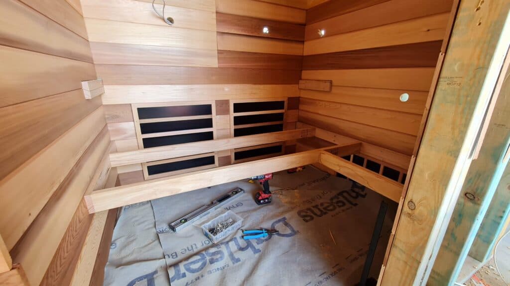 Completed custom sauna assembly undergoing workshop inspection