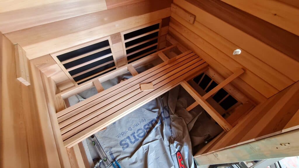 Wood bench and heater panels inside a custom sauna