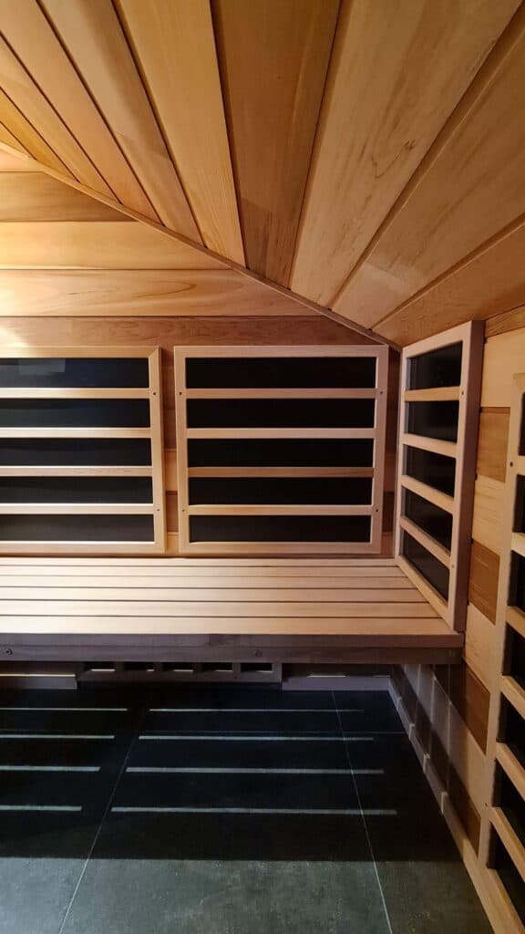 Heater panels positioned within a wood sauna interior